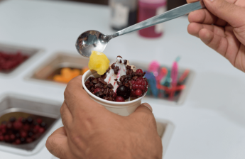 A man adding toppings to a frozen yogurt